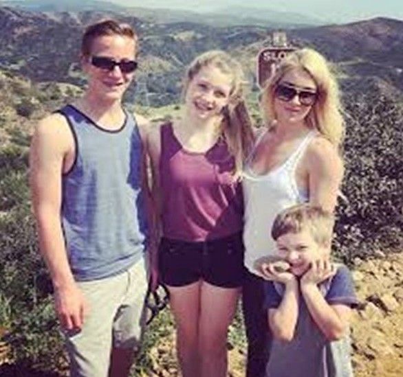Michael Bisping turns photographer as his wife and kids pose with a scenic picture in the background.